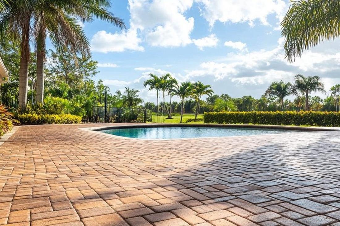 Restored paver pool deck framed by palms and tropical landscaping