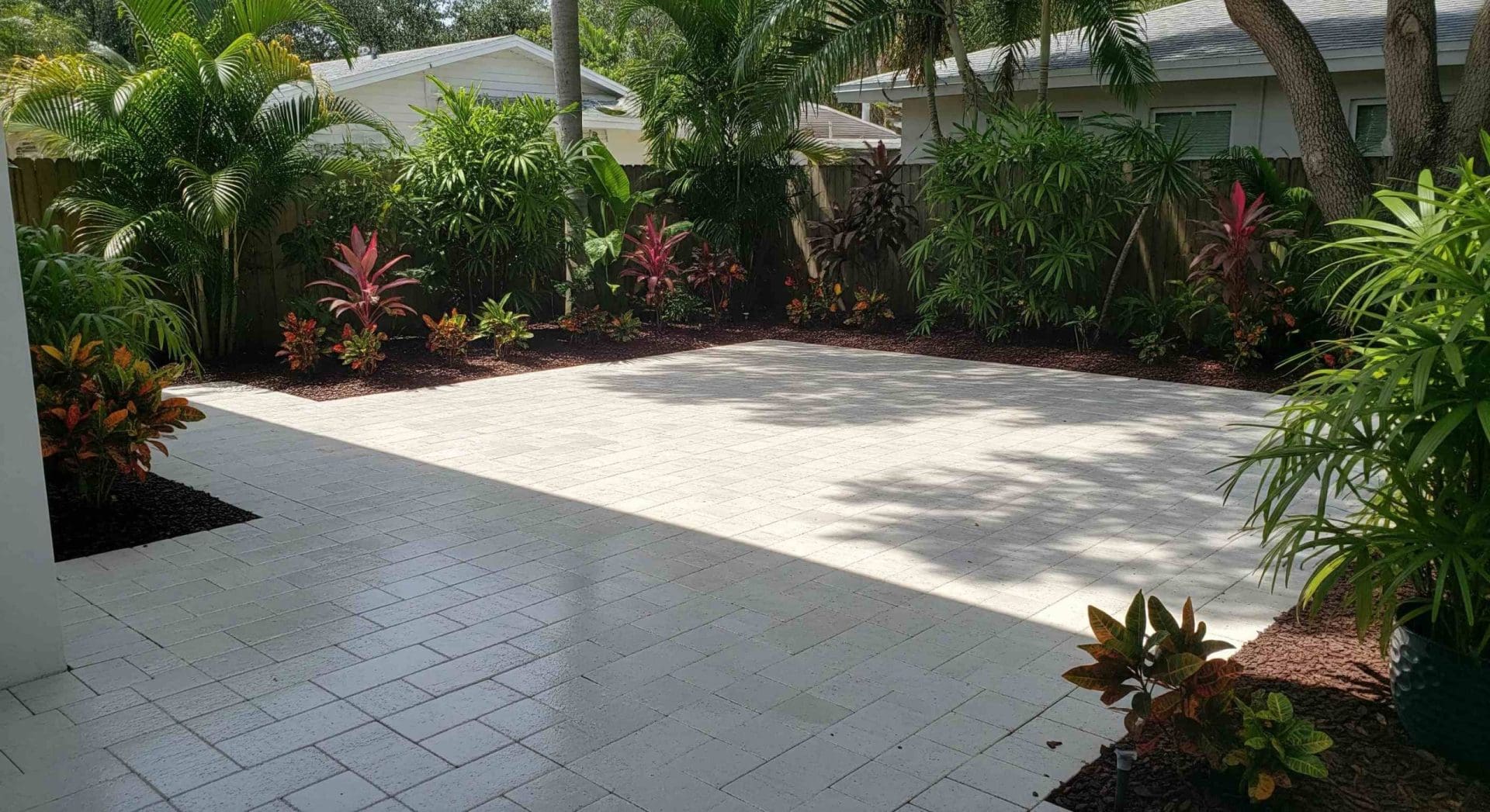 A close-up of sealed pavers around a backyard pool deck in Palm Harbor, Florida, highlighting the benefits of sealing pavers with clean grout lines, a water-resistant surface, and subtle reflections from ambient lighting.